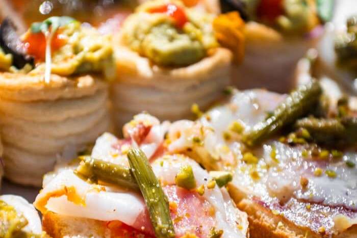 Assorted gourmet appetizers featuring canapés, puff pastries, seafood, and fresh garnishes arranged for a luxury dining presentation.
