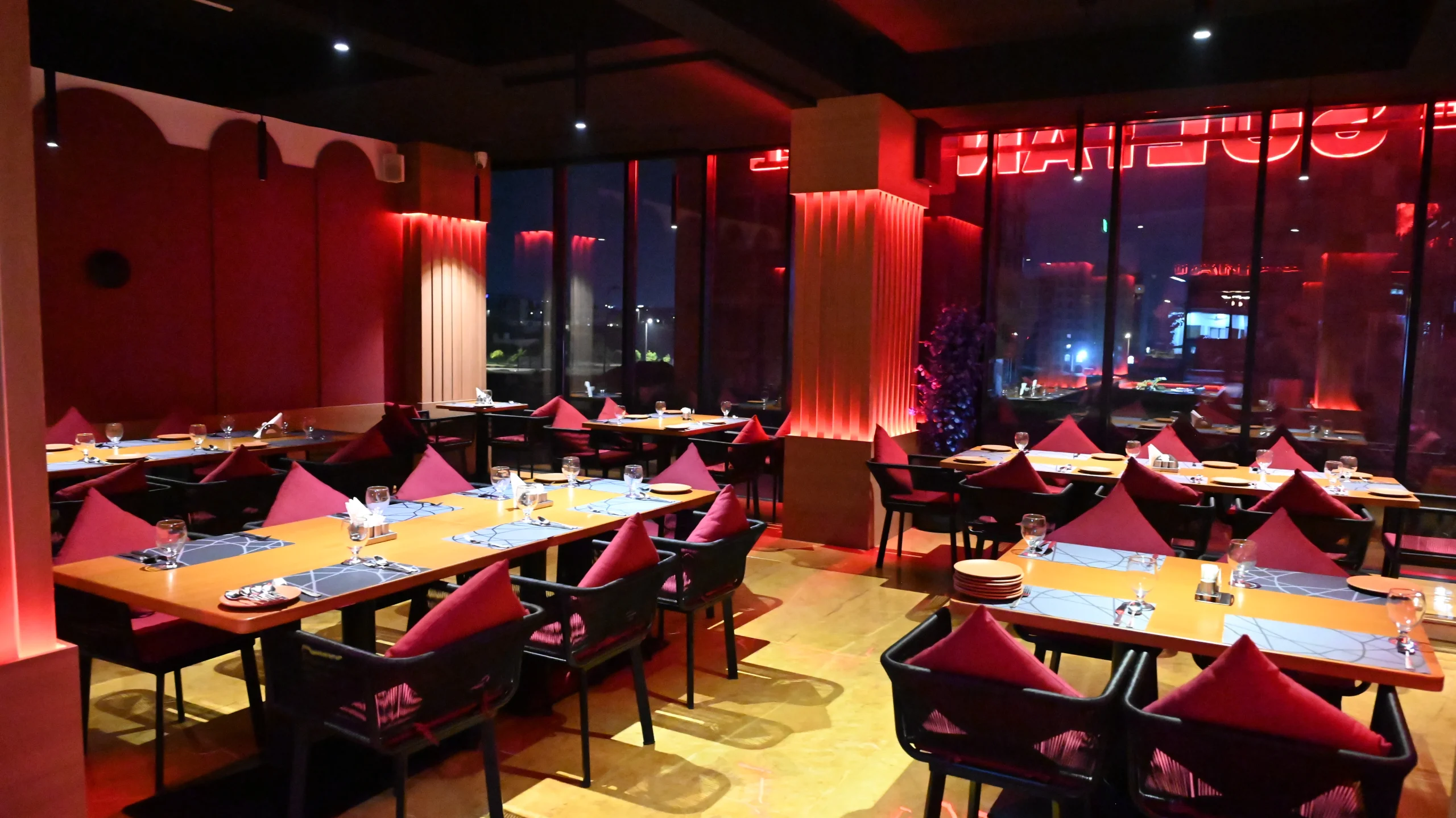 Elegant dining room interior at a luxury restaurant near Islamabad Airport with large view windows.
