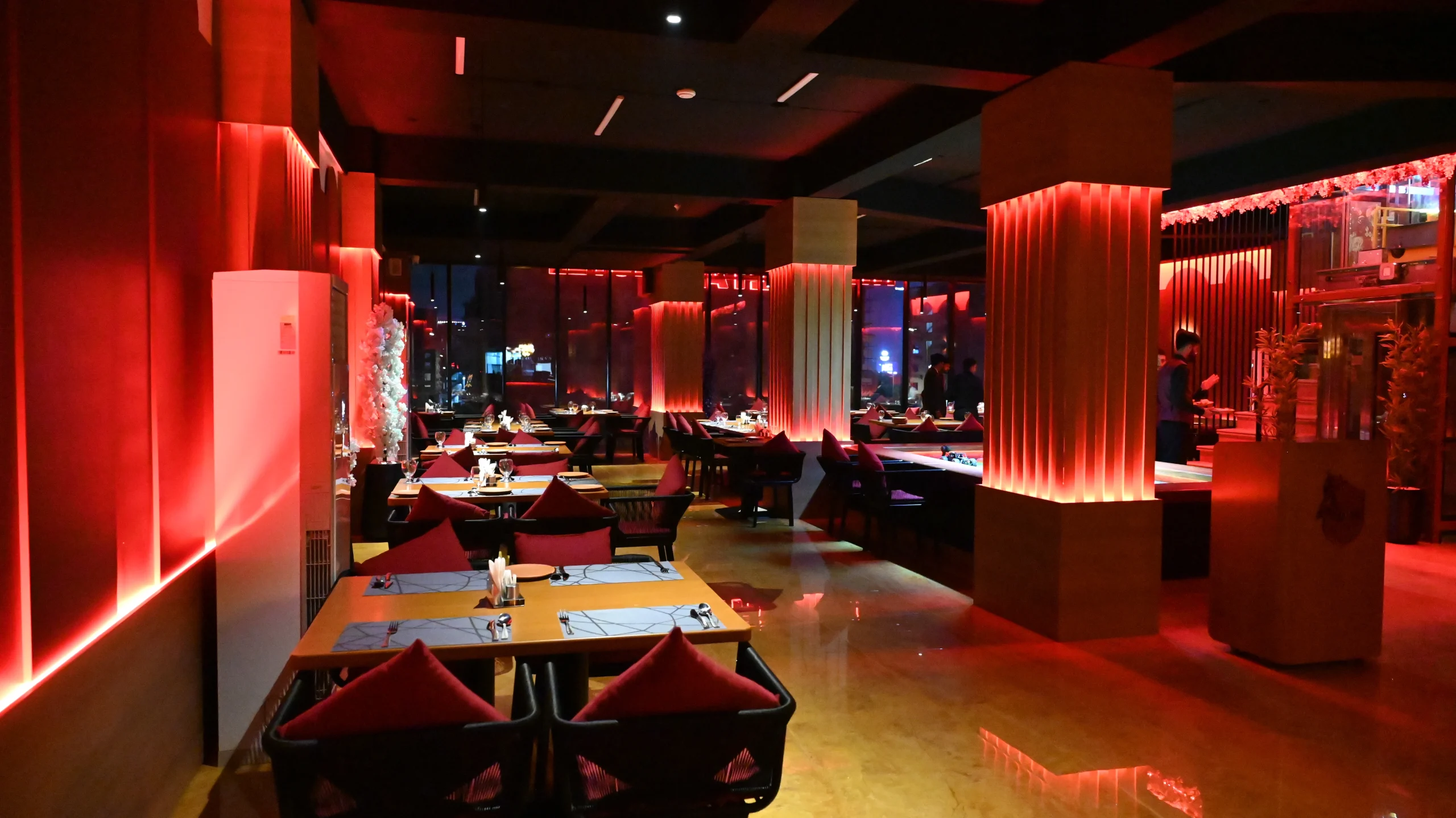 Modern dining space at a luxury restaurant near Islamabad Airport featuring ambient red LED lighting.